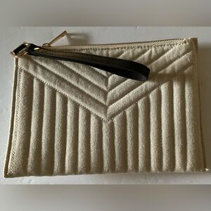 Cream colored coin purse with brown strap and zipper